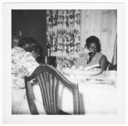 Two Women Sit at Dining Table in Front of a Window, circa 1959