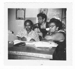 Three Women Sit Around a Desk, circa 1960