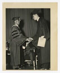 A Graduate Shakes Hands With James P. Brawley on stage at Commencement, circa 1965