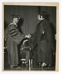 A Graduate Shakes Hands With James P. Brawley on stage at Commencement, circa 1965