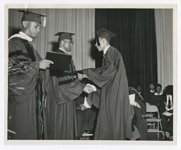 A Graduate Shakes Hands With James P. Brawley on stage at Commencement, circa 1965