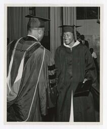 A Graduate Shakes Hands With James P. Brawley on stage at Commencement, circa 1965