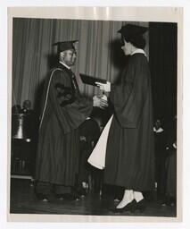 A Graduate Shakes Hands With James P. Brawley on stage at Commencement, circa 1965