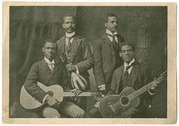 George A. Towns Standing With Men Holding Instruments, circa 1920