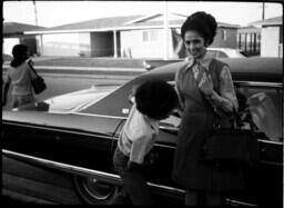 Boy and Woman Stand by a Cadillac, circa 1972