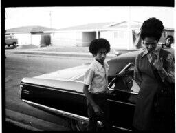 Boy and Woman Stand by a Cadillac, circa 1972