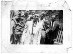 Group of Men Stand in Front of a Fence, circa 1942