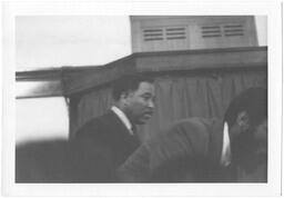 Unidentified Man Walks Behind Dick Gregory, circa 1969