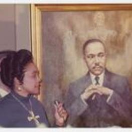 Coretta Scott King stands beside a portrait of Martin Luther King Jr.