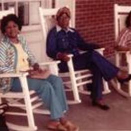 Dr. Addie Mitchell, Dr. Elynor Brown, and Professor Carol Miller sit in rocking chairs.
