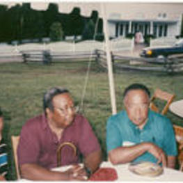 Alex Haley sits with C. Eric Lincoln and two women at a table outside of his house in Tennessee,