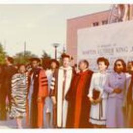 President Hugh Gloster with Coretta Scott King and unidentified persons standing in front of the Dr. Martin Luther King Jr. statue.