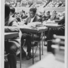 Joseph E. Lowery shown studying with other men in a stadium.