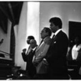 Maynard Jackson sings along with other people at a church.