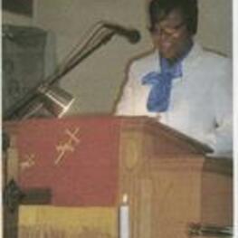 Dr. Lewis speaks to the congregation from behind a podium. Written on verso: Dr. Francena Lewis.