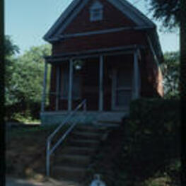 A view of a shotgun house. Text from slide presentation: Shotgun houses are narrow, front-gabled dwellings one room wide and two to three rooms deep. They get their name because it was said you can stand on the front porch of a shotgun house and shoot clear through the back door without hitting anything.