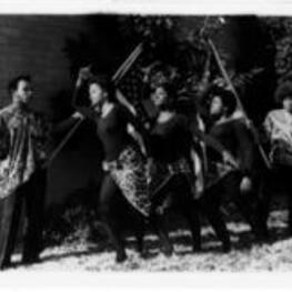 Three unidentified women stand in front of a brick building and bushes. Their arms stretched out in dance poses. Two unidentified men stand behind them holding up American flags. On verso: Echoes of a Dream, a dramatic bicentennial production of Boggs Academy, Keysville, Georgia, is  widely acclaimed program of dance, poetry and song speaking to the question of "should blacks celebrate the bicentennial?" Echoes will be presented on (date), at (place), at (time). It is sponsored by (name of sponsor). The public is invited.