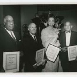Paul Clifford, Clayton Yates, Josie Murphy and Truman Gibson stand holding plaques.