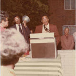 Joseph E. Lowery shown speaking at a podium during an outdoor event.