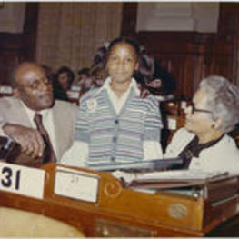 Grace Townes Hamilton at her desk with a unidentified man and a young page at the Georgia House of Representatives.
