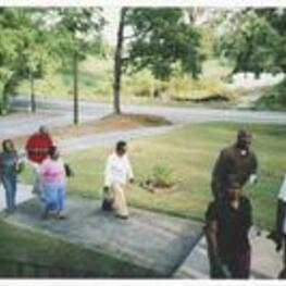 A group of people walk into church. Written on verso: Vacation Bible School - 2007. Marching to church unknown woman, Greg Lewis Jr., Evelin Perren, Leila Marcus, Francena Lewis, Aaron Christian, Don Green.