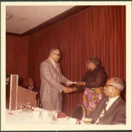 Dr.Vivian Wilson Henderson, president of Clark College, presenting an award to an unidentified woman at an award ceremony for Clark College, possibly at the Atlanta Marriott.