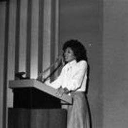 Vivian Malone Jones speaks from a podium at an event.