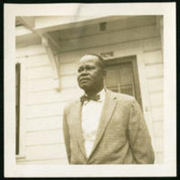 Trezzvant Anderson stands in front of a house in a suit.