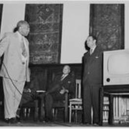 Dr. Harry V. Richardson  standing on stage in Gammon Chapel with others a television.