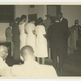 Indoor view of men and women at certificate presentation. Written on verso: Presenting lay speaker certificate at the Tennessee Annual Conference Nashville, Tenn. June 1963.