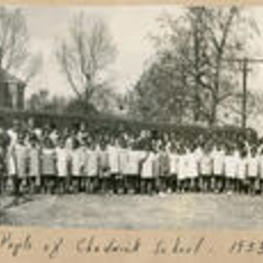 A group of Chadwick School pupils stand outside in a yard.