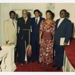 Indoor group portrait of men and women. Written on verso: "Inaugural Concert 1985; Big Bethel AME Church; L-R: Unidentified Man; Unidentified Woman; Dr. Calvert H. Smith; Rosalyn Burroughs; Bishop Frederick Talbot".