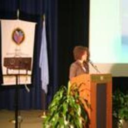 An unidentified woman speaks from the podium.