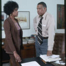 Dr. Vivian Wilson Henderson, president of Clark College, and an unidentified woman in an office.