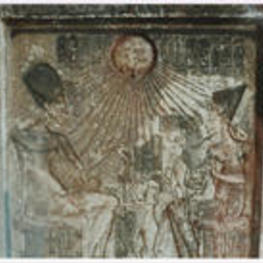 The pharaoh, his wife, and their children sit under the sun's rays with hieroglyphics.