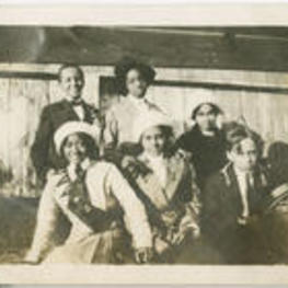 Nora E. Floyd sits with a group of unidentified young men and women.