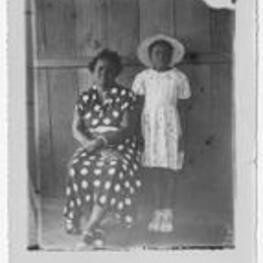 Portrait of an unidentified woman seated with an unidentified girl standing next to her.