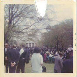 A crowd gathers outside for a commencement ceremony.