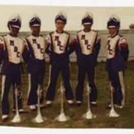 Outdoor group portrait of 5 young people wearing marching band uniforms.