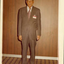 Dr. Brailsford R. Brazeal wearing a suit and tie and a nametag.