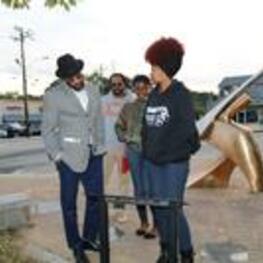Rico Chapman (with hat), Delvon Benson (back), and students read a plaque in Southwest Atlanta.