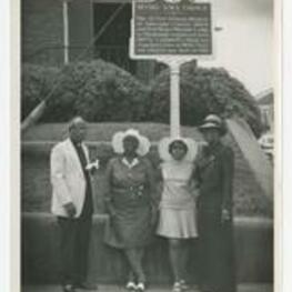 George A. Sewell and women stand in front of the historic site sign of Bethel AME Church.