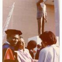 Coretta Scott King with unidentified persons in front of Dr. MLK statue.