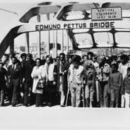 John R. Lewis and Coretta Scott-King walk across Edmund Pettis Bridge on the ten-year anniversary of Selma's Bloody Sunday.