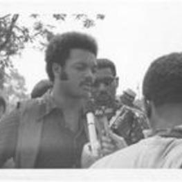 Jesse Jackson is interviewed at the March Against Repression. Written on accompanying document: Being interviewed.