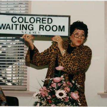 Evelyn G. Lowery Holding a "Colored Waiting Room" Sign, circa 1995