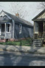 A view of two shotgun homes. Text from slide presentation: Porches provided places to sit and enjoy whatever cooling breezes may have been stirring and were also places to visit neighbors. Both of these roles are still important to day.