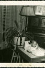 Wyonella Marie Henderson, daughter of Dr. Vivian Wilson Henderson and Anna Henderson, sits in a highchair.