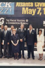 Maynard Jackson and others in front of a Jazz event poster.