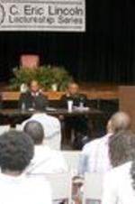A panel including Illya Davis (left), and Dr. Clarence G. Newsome (center), speaks to a group.